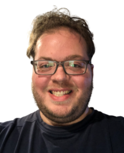 Close-up portrait of a person with glasses wearing a black t-shirt, featuring a warm smile and casual appearance