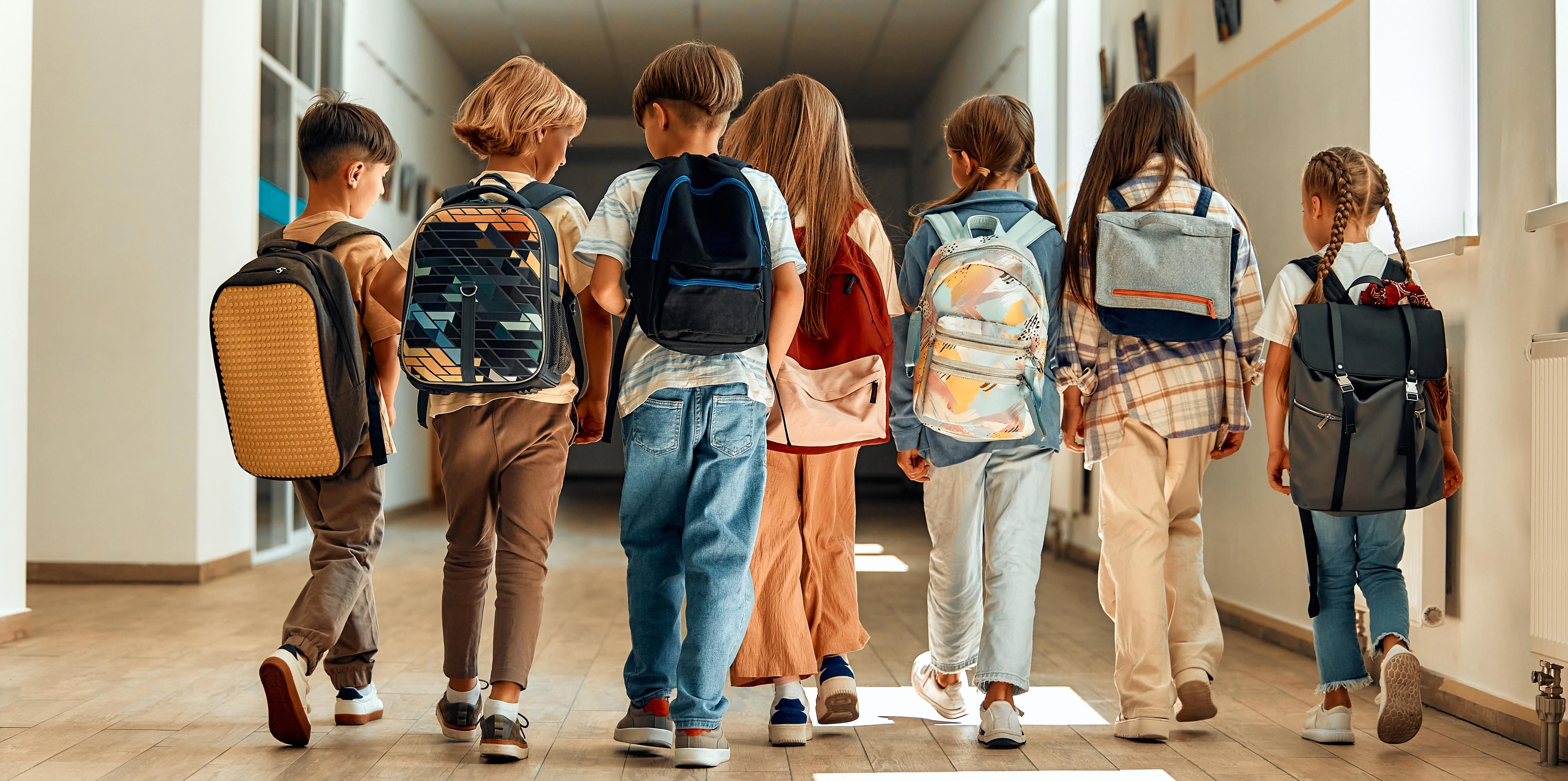 A group of students walks down the hallway at school.