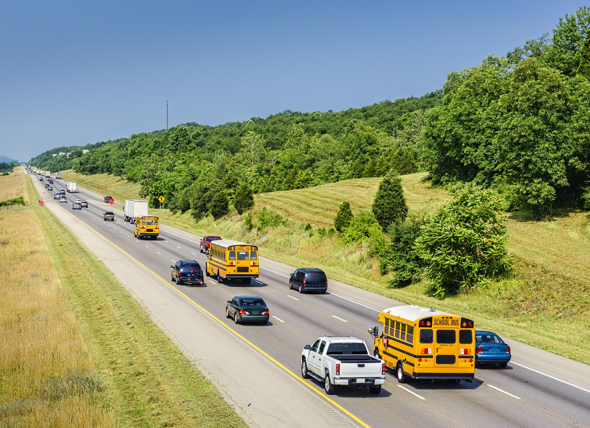 Traditional yellow school buses and small vehicles both transport students to school in an example of supplemental school transportation.