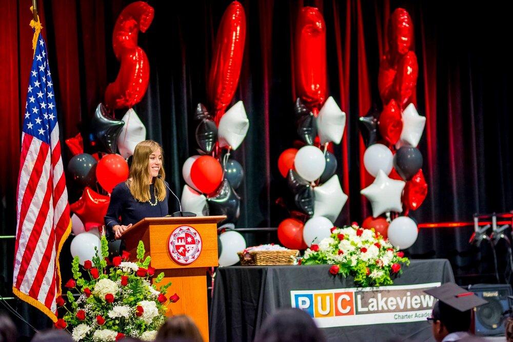 Graduation ceremony podium with American flag, red and white balloon arrangements, and floral decorations at PUC Lakeview Charter Academy